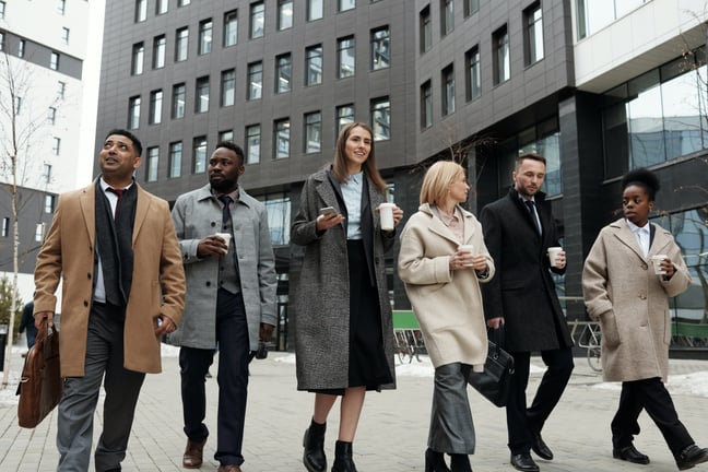 People in business wear walking together with coffee