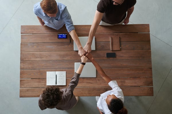 Startup team fistbumping over table