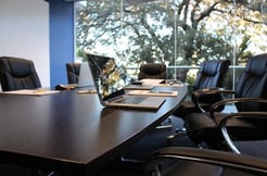 Conference table with open laptop on it