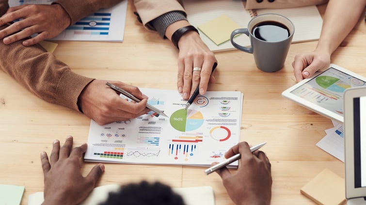 people around a table examining graphs