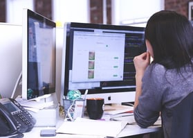 Tech person looking at desktop computer